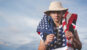 Un homme avec un drapeau Américain, sur un fond de nuage.